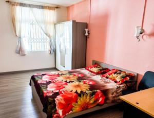 a bedroom with a bed with a flowered blanket at Residential House 3 Bedroom, 1 Bathroom Entire unit in Beau Bassin in Beau Bassin