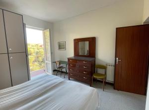 een slaapkamer met een bed, een dressoir en een spiegel bij Appartamento vista mare e uliveto a Tellaro in Tellaro