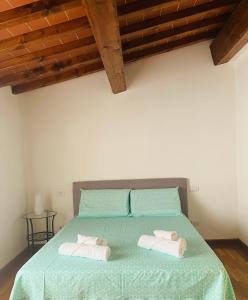 a bedroom with a green bed with two towels on it at Charming Townhouse with Garden in Impruneta