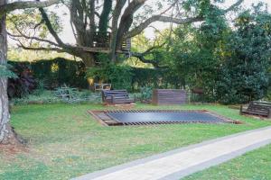 un parco con due panchine e un albero di e11even Boutique Bed & Breakfast a Newcastle