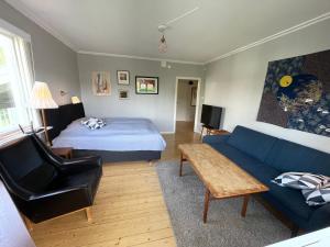 a living room with a bed and a blue couch at Stor etta på lugna söder in Växjö