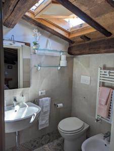 een badkamer met een wastafel, een toilet en een spiegel bij Lizium Spoleto in Spoleto