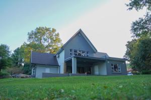 una casa su una collina con un campo verde di e11even Boutique Bed & Breakfast a Newcastle