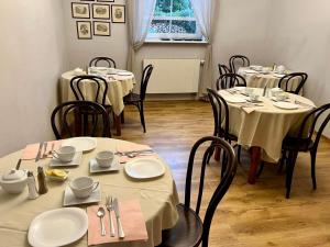 une salle à manger avec des tables et des chaises blanches dans l'établissement Motel Orzeł, à Szczecinek