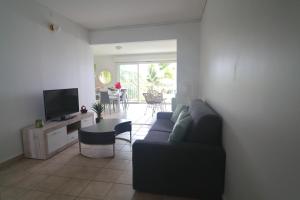 a living room with a couch and a tv at Magnifique appt Crystal Beach in Saint-François