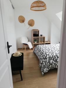 sypialnia z czarno-białym łóżkiem i krzesłem w obiekcie Chambre d'hôtes chez Marie w mieście Coëtmieux