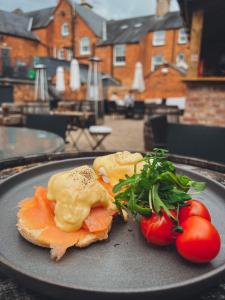 a plate of food with salmon and tomatoes on a table at The Red Lion Inn in Rothwell