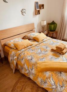 1 dormitorio con 1 cama con edredón amarillo y blanco en Gîte le grand chacel, en Sourcieux-les-Mines