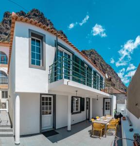 una casa bianca con tavolo e sedie di Casa de Praia no Paul do Mar a Paul do Mar