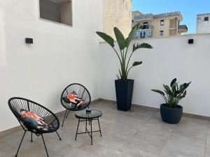 2 sillas y una mesa en un patio con plantas en GL rooms and apartments en Bari