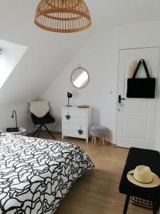 sypialnia z łóżkiem i kapeluszem na stole w obiekcie Chambre d'hôtes chez Marie w mieście Coëtmieux