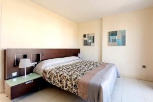 a bedroom with a bed and a desk with a lamp at Maurici Park in Empuriabrava