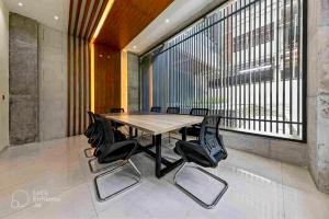 a table and chairs in a room with a large window at Gulshan Stylish 3 bedroom Luxury Apartment in Prime location in Dhaka