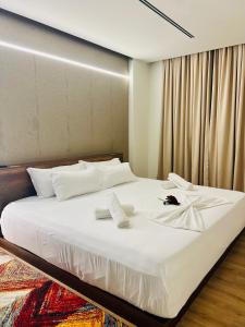 a bedroom with a large bed with white sheets at Green Coast Resort & Residences 94 in Palasë