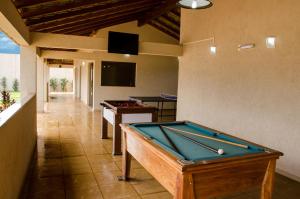 a pool table in a room with two tables at Vale dos Carajás Hotel in Parauapebas