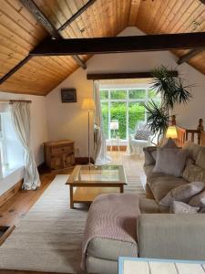 a living room with a couch and a table at Converted Victorian Coach House on the North Coast in Coleraine