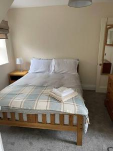 a bedroom with a bed with two towels on it at Converted Victorian Coach House on the North Coast in Coleraine