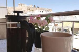 アテネにあるAcropolis Area Flat with Parthenon Viewsのコーヒーと花瓶