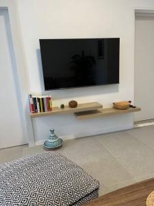 een woonkamer met een flatscreen-tv aan de muur bij Simply with love-haifa in Haifa