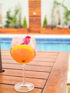 a drink sitting on a table next to a pool at Éden Pampulha - Hotel Coworking in Belo Horizonte