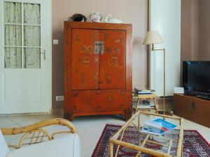 a living room with a red cabinet and a glass table at Maison Saloine in Saintes