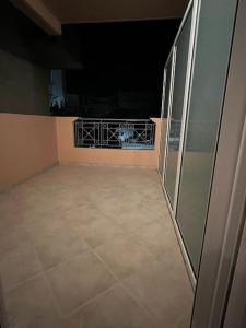 ein großes leeres Zimmer mit Balkon in der Nacht in der Unterkunft Αγρίνιο κέντρο ΔΣ A2 in Agrinio