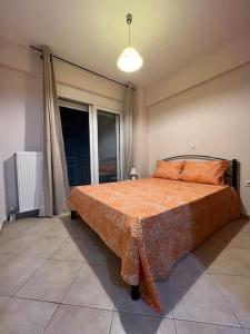 ein Schlafzimmer mit einem großen Bett mit einer orangefarbenen Decke in der Unterkunft Αγρίνιο κέντρο ΔΣ A2 in Agrinio