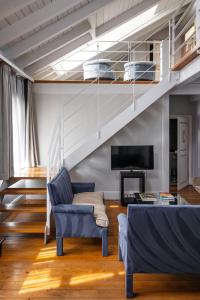 a living room with a staircase and a couch at Hotel Le Place d'Armes - Relais & Châteaux in Luxembourg