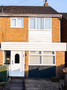a red brick house with a white door at Luxurious 3-Bed House in Dudley - DY1 in Dudley