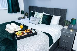 een bed met een dienblad met eten en drinken erop bij Luxurious 3-Bed House in Dudley - DY1 in Dudley