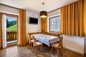 una sala da pranzo con tavolo, sedie e una finestra di Bachwiesl Hof Apt Ocker a Proves