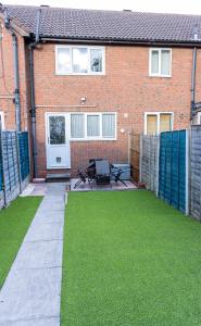 a house with a patio and grass in front of it at Perfect for Long Stay Workers Leisure Families in Wolverhampton