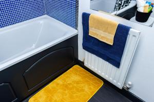 a small bathroom with a yellow and blue rug at Perfect for Long Stay Workers Leisure Families in Wolverhampton