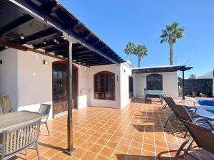 un patio di una casa con sedie e tavolo di VILLA ALICIA by JK Lanzarote a Puerto del Carmen