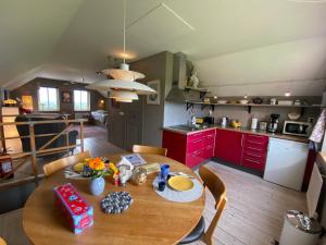 cocina con mesa de madera y armarios rojos en B&B Borgunda, en Borgunda