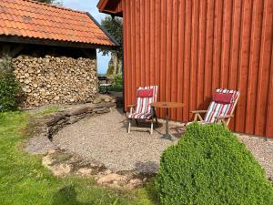 two chairs and a table next to a red building at B&B Borgunda in Borgunda