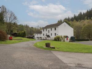 a white house on a hill next to a road at Canadian Cabin No 38 in Keswick