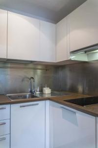 a kitchen with white cabinets and a sink at EasyTopStay - Piazza Venezia Charming & Bright Apt in Rome +6 photos