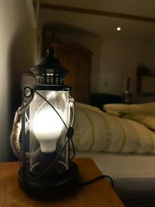 a lantern with a light on a table next to a bed at Ferienapartment Opitz - Zugspitzregion in Ohlstadt