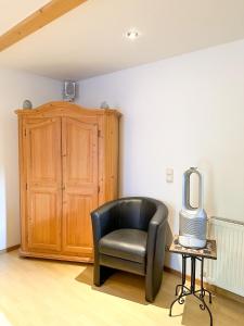 ein schwarzer Stuhl in einem Zimmer mit einem TV auf einem Tisch in der Unterkunft Ferienapartment Opitz - Zugspitzregion in Ohlstadt