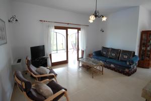 ein Wohnzimmer mit einem blauen Sofa und einem TV in der Unterkunft Sara - sea view villa with private pool in Calpe in Calpe
