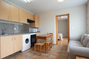 a kitchen with a couch and a table in a room at Apartamentos Aldea del Puente in Cangas de Onís