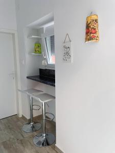 a small kitchen with a counter and a stool at Apartment Lucija in Jablanac