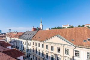 een groep gebouwen met een klokkentoren op de achtergrond bij Urban Elegance Retreat in Bratislava