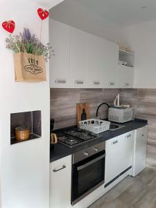a kitchen with white cabinets and a stove top oven at Apartment Lucija in Jablanac