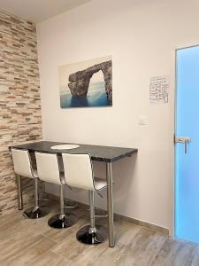 a black table with white chairs in a room at Apartment Lucija in Jablanac