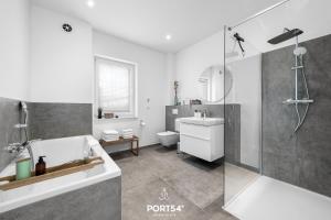 a bathroom with a shower and a tub and a toilet at Ferienhaus Villa Dein Zuhause am Meer in Büsum