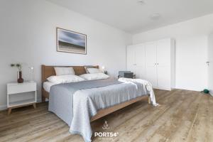 a bedroom with a bed and a wooden floor at Ferienhaus Villa Dein Zuhause am Meer in Büsum
