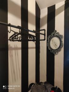 eine Uhr an einer Wand mit schwarzen und weißen Streifen in der Unterkunft Villa Vakalis in Ioannina