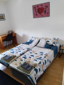 Bett mit blauer und weißer Decke in einem Zimmer in der Unterkunft Bagins Apartman in Kostolac